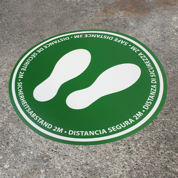 Im Bild: Grüne Bodenmarkierung mit Hinweis auf 2 Meter Sicherheitsabstand
